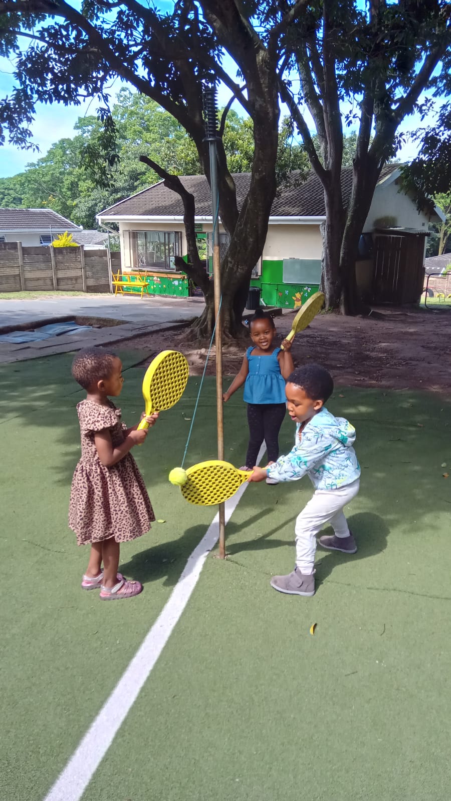 Children playing swingball in Fairy Glen’s tree-shaded grounds