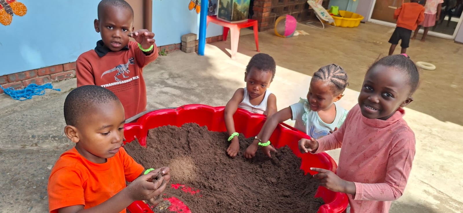 Children exploring sand together at Fairy Glen Preschool