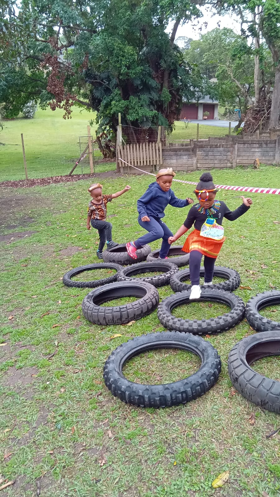 Children enjoying an outdoor tyre obstacle course