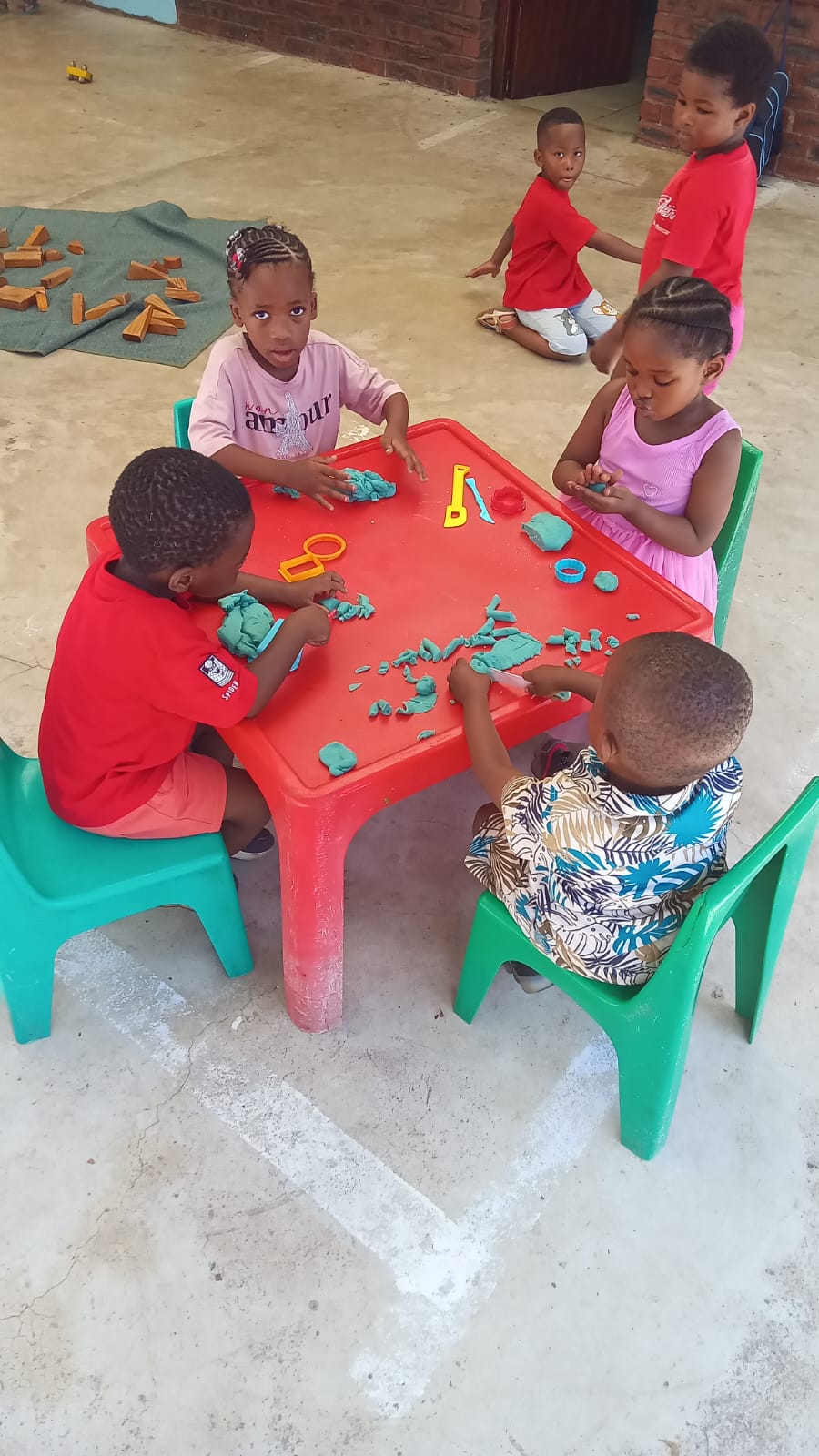 Young children exploring blue playdough together